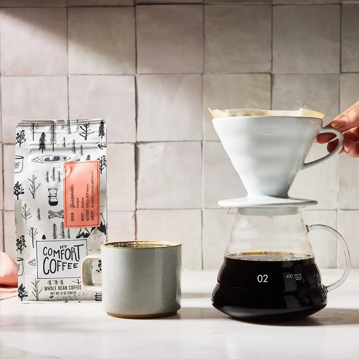 Person making coffee using a pour-over method using Mt Comfort Guatemalan Coffee Medium Roast
