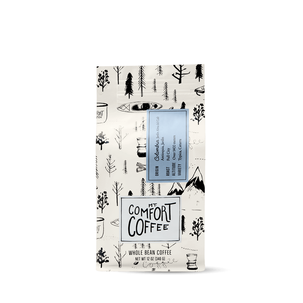 Packaging of Mt Comfort Colombian Coffee, Full City Roast, featuring a black and white design with coffee illustrations.