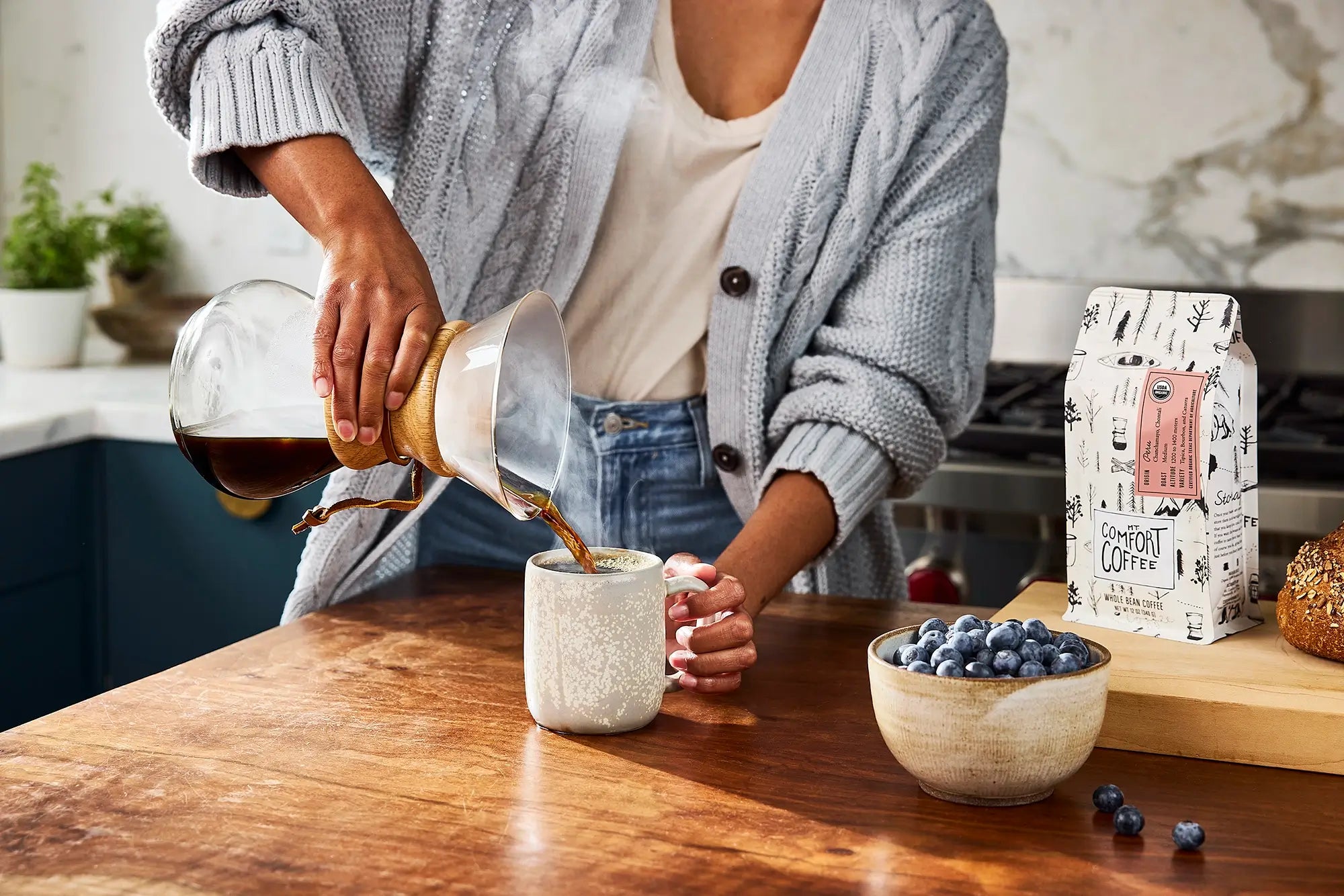 Woman pouring Mt. Comfort's specialty coffee into mug from Chemex pour over.